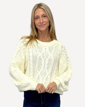 Load image into Gallery viewer, Woman wearing a cream sweater and blue jeans on a white background